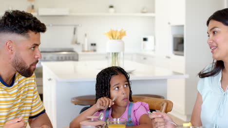 african american family enjoying breakfast together in bright, modern kitchen