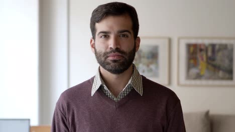 front view of happy joyful bearded guy posing indoors