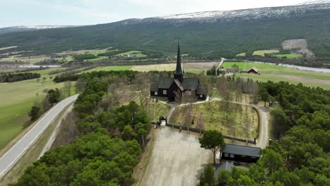 Lesja-Church-in-Innlandet-Norway---Aerial-around-historic-church-and-graveyard