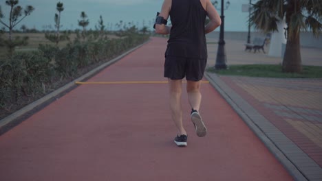 man running on a coastal path at dusk