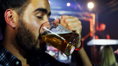 man having a mug of beer at a concert 4k