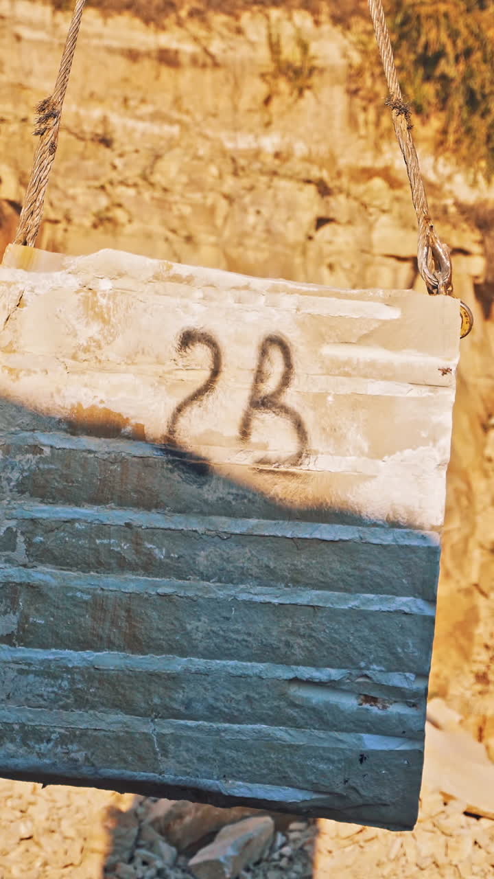 Mine of extration of marble. View of marble building block and crane hook Vertical video