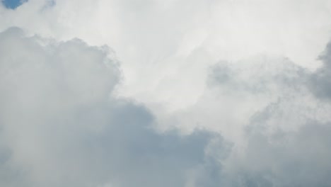 Billowing-clouds-race-across-a-vibrant-sky,-illuminated-by-sunlight-in-a-fast-paced-timelapse