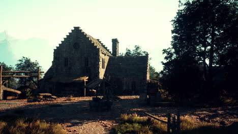 an old stone building with a thatched roof and a wooden fence in front of it