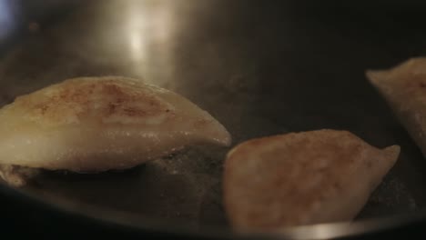 golden brown dumplings taken out of frying pan - close up