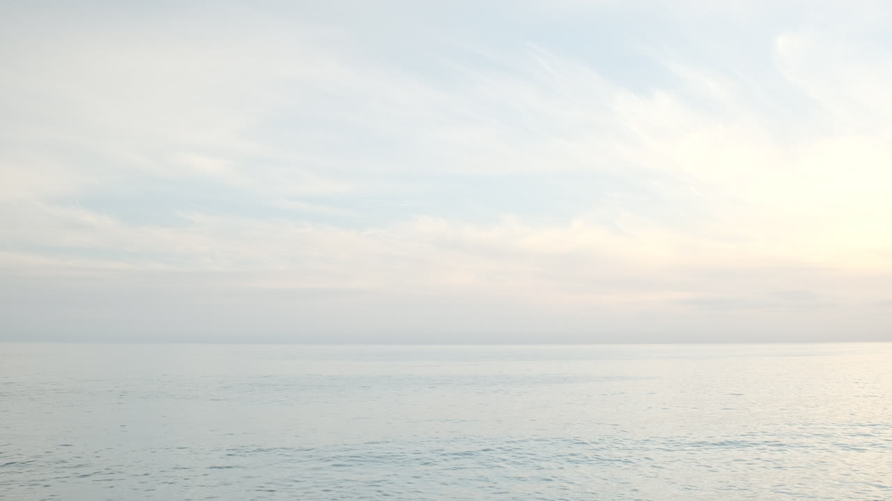 골든 아워에 말리부 캘리포니아의 큰 바위 해변에 하늘의 부분적으로 흐린 하늘