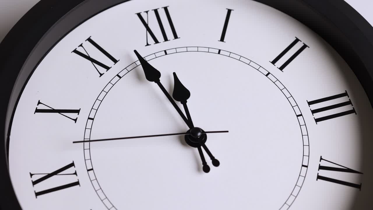 película de lapso de tiempo. gran reloj de pared blanco fija la hora para las 12.00 horas. la manija de minutos roja sigue funcionando. números romanos