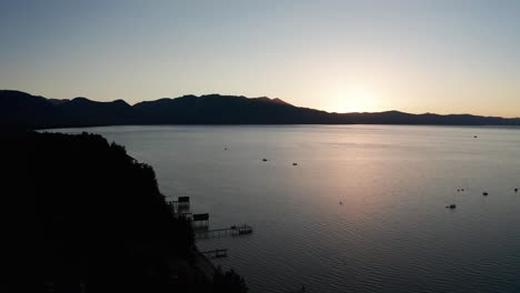 Toma-Aérea-Descendente-Y-Panorámica-Del-Lago-Tahoe-Al-Atardecer-En-El-Verano