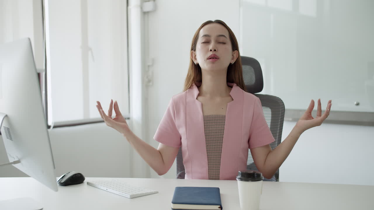 Spreading her hands upwards while closing her eyes, a woman is doing a simple relaxation exercise.