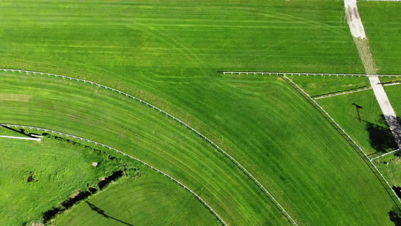 Aerial drone view of Milan racetrack with grass surface, showing full layout, arena, grandstands, and urban skyline