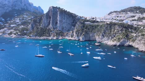Aerial-drone-dolly-shot-of-boats,-yachts-on-the-coastline-of-Capri,Italy