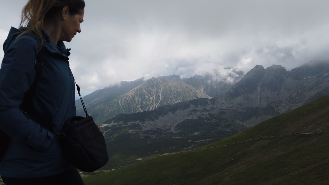 toma cinematográfica de una mujer caminando en la cima de una montaña en las montañas tatra admirando el paisaje-1