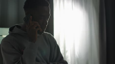 close up of young man at home talking on mobile phone reacting and looking upset after getting bad news 2
