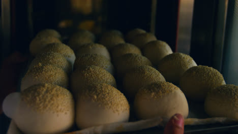 chef inserting tray of unbaked rolled dough 4k