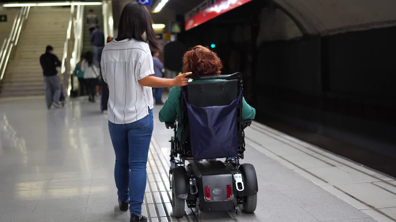 Woman in Wheelchair Being Assisted in Subway Station