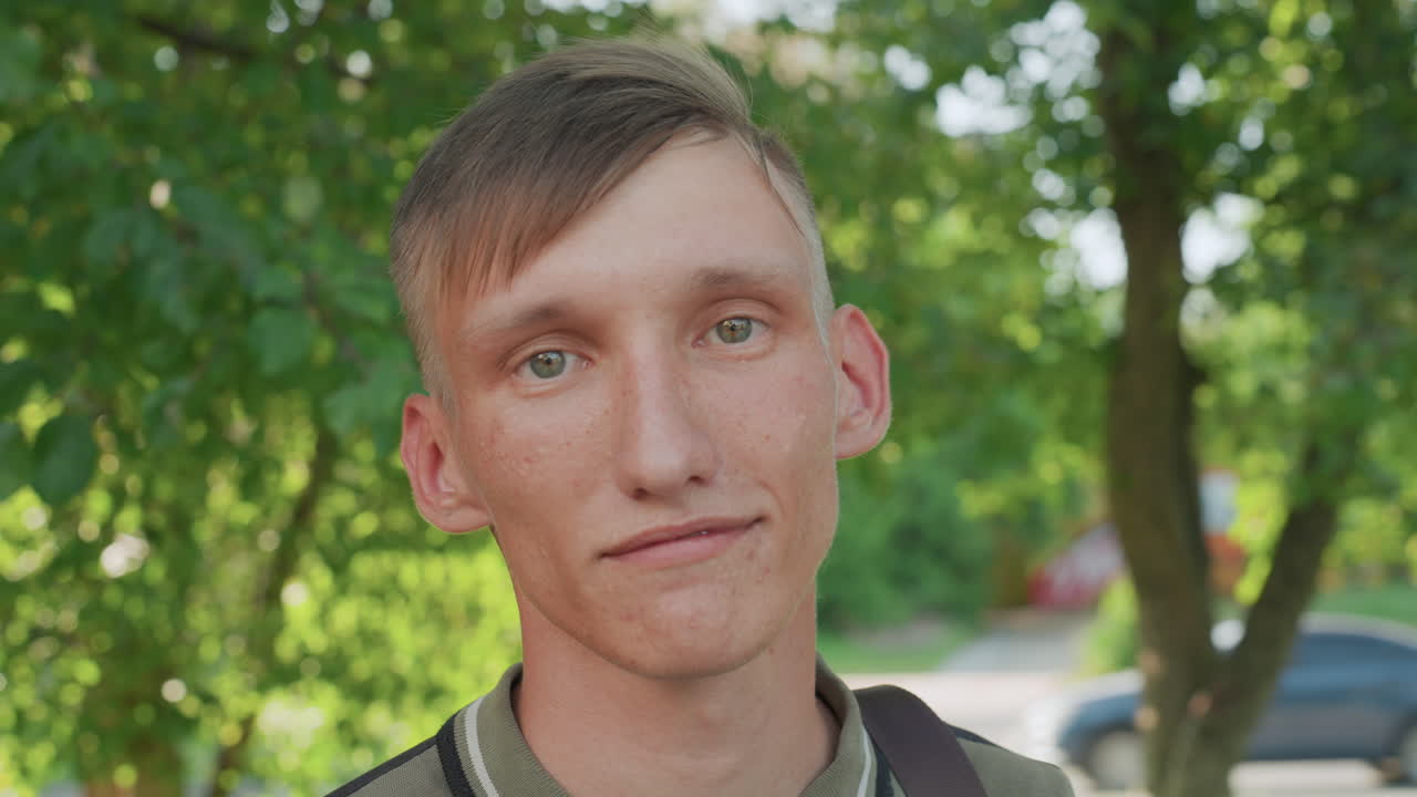 Intimate Forest Portrait, Closeup Of Young Man Smiling Subtly Amid Greenery And Dappled Sunlight, Candid Shot Capturing Young Man With Serene Smile Beneath Lush Tree Foliage And Gentle Sunlight