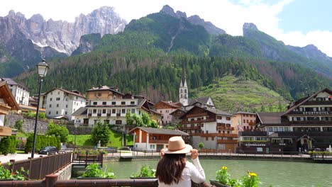 woman enjoying alleghe village view in the foothills of green valley of dolomites