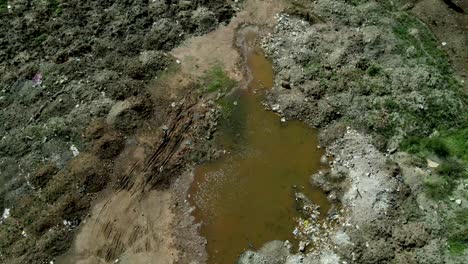 Schmutziges-Stehendes-Wasser-Umgeben-Von-Zerstörter-Natur-Nach-Dammangriff-Mit-Wasserhyazinthe-Und-Ausgetrocknet