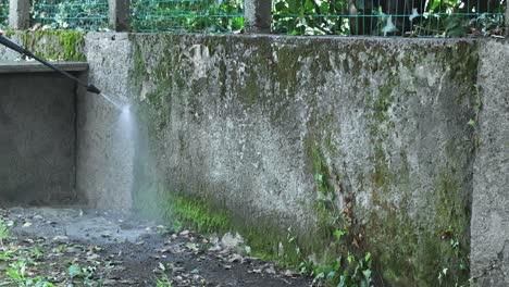 Man-uses-pressure-washer-to-remove-dirt-from-concrete-driveway