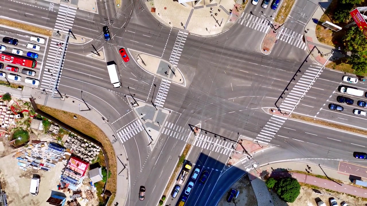Wide view of asphalt road crosswalks, Bratislava, Slovakia. High angle drone shot of empty pedestrian zebra crossings and traffic islands on a sunny day.