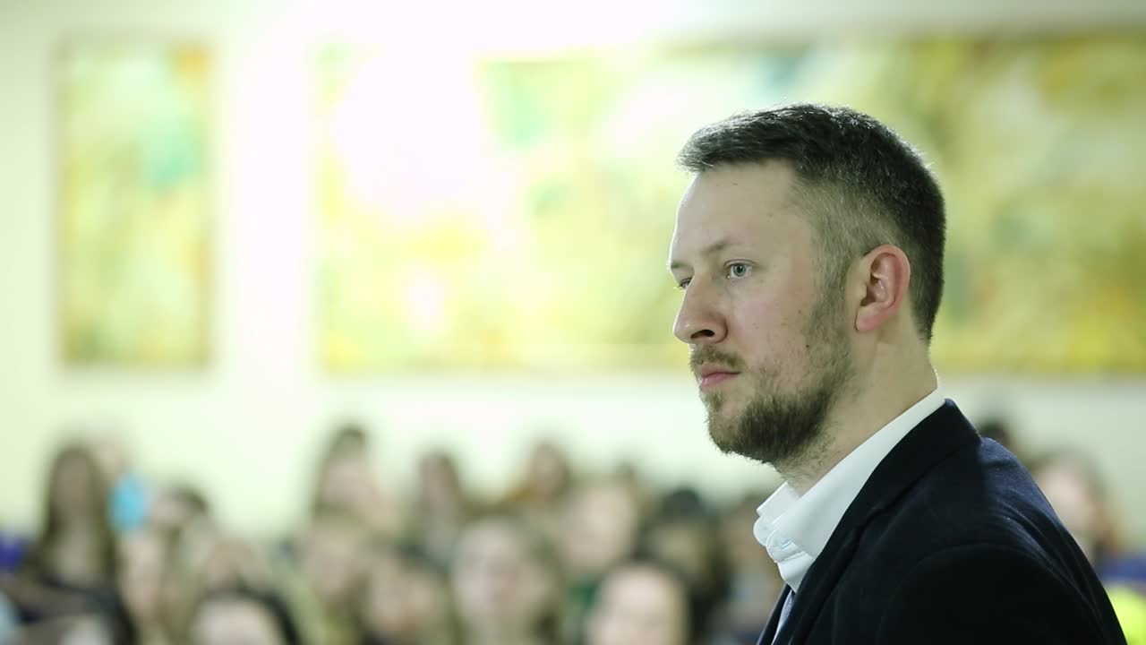 Uomo che tiene un discorso in sala conferenze. Un uomo d'affari tiene un discorso davanti a un vasto pubblico in una sala conferenze.