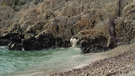 turquoise green ocean water gently crashes onto pebble limestone sand of blue lagoon beach croatia