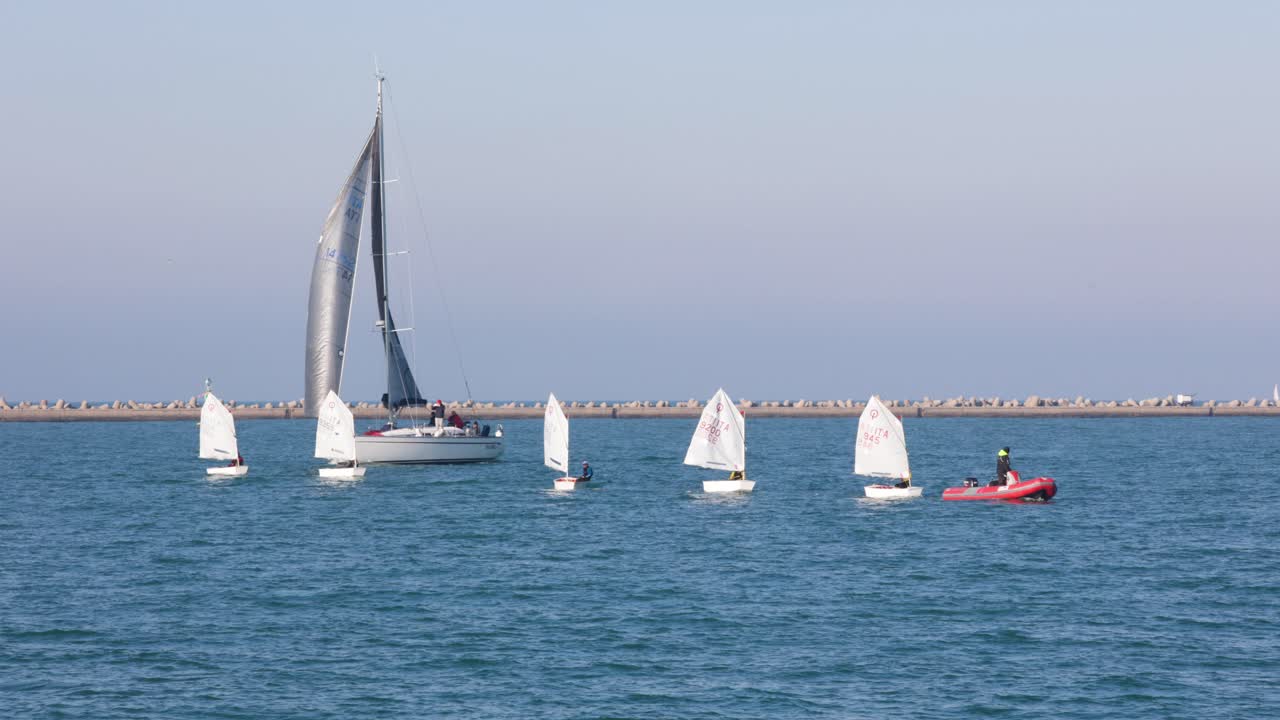 Team of Dinghy small sailboat on blue sea practice sport with instructor