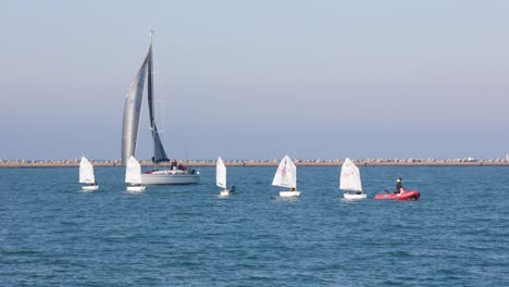 team of dinghy small sailboat on blue sea practice sport with instructor
