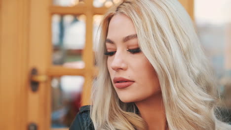 portrait of pretty young blonde woman smiling in makeup with lipstick looking at camera