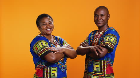 confident ethnic couple posing in studio with colorful clothes