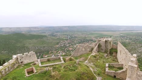 Una-Vista-Aérea-Muestra-La-Fortaleza-Blagaj-Y-El-Pueblo-Que-Domina-En-Mostar-Bosnia