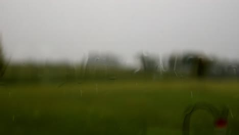 Lluvia-A-Veces-Fuerte-Contra-Una-Ventana,-El-Chapoteo-De-Las-Gotas-Contra-El-Vidrio,-Fascinante