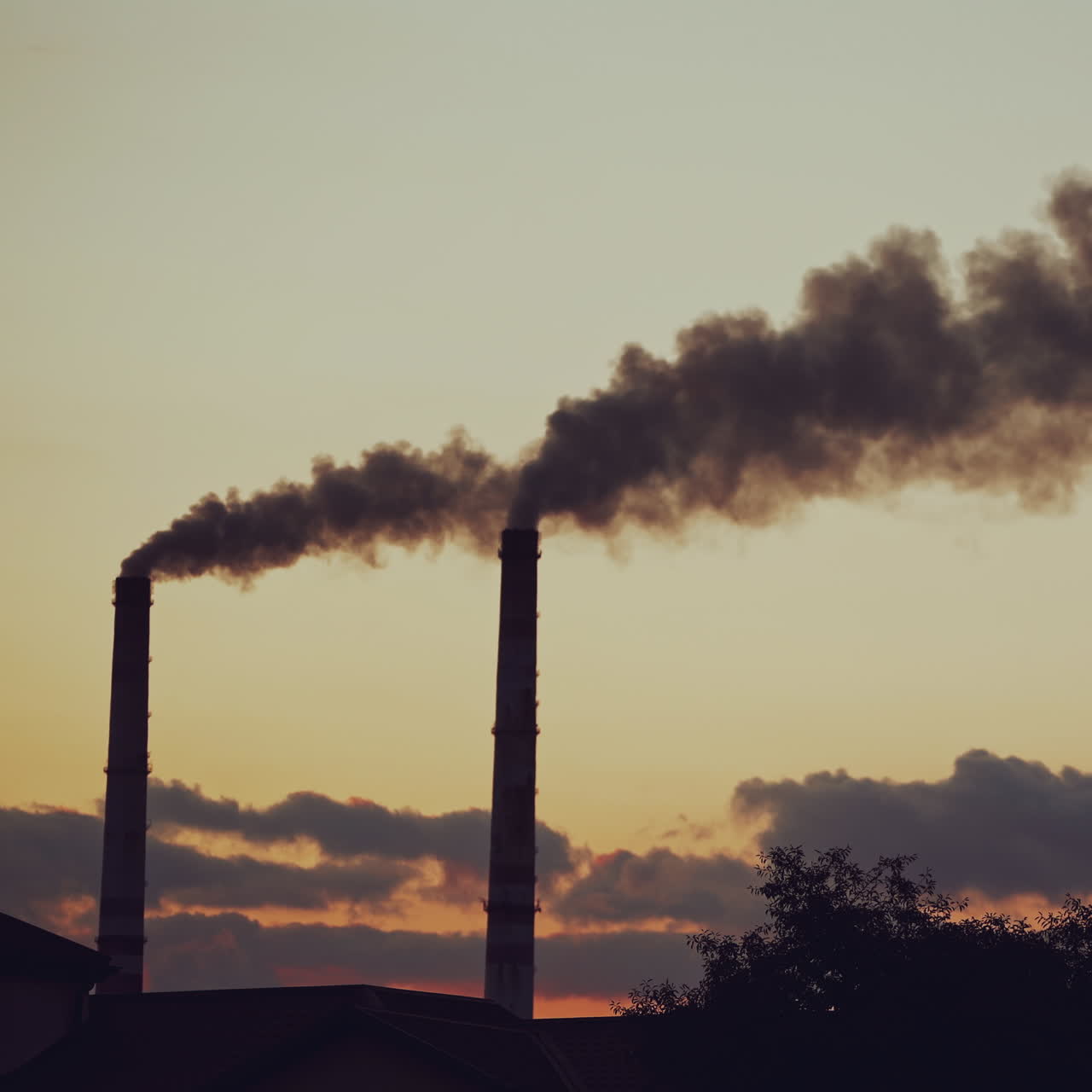 Air pollution. Industrial pipes with thick smoke pollute the atmosphere. Two big pipes with toxic smoke on the natural background in the evening.