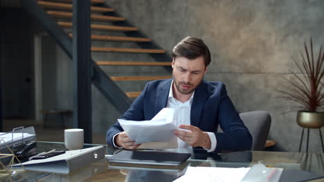 Frustrated-businessman-throwing-documents-away-at-workplace