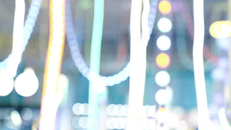 colorful garlands and a neon light bulb in a shape of a snowflake hanging in the shopping center