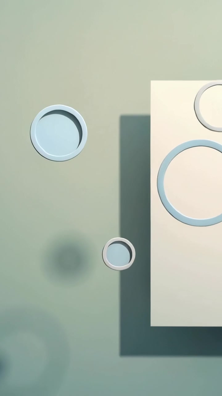 Vertical video: On start rings and discs drifting past pale panel on teal gradient, forming cluster