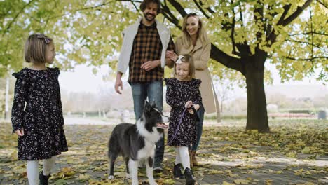 Family-and-dog-walking-in-the-autumn-park