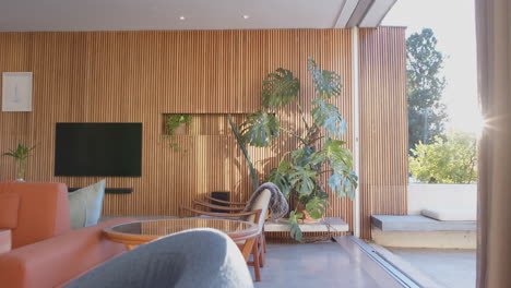 modern living room with large indoor plant and wooden panel wall design, copy space