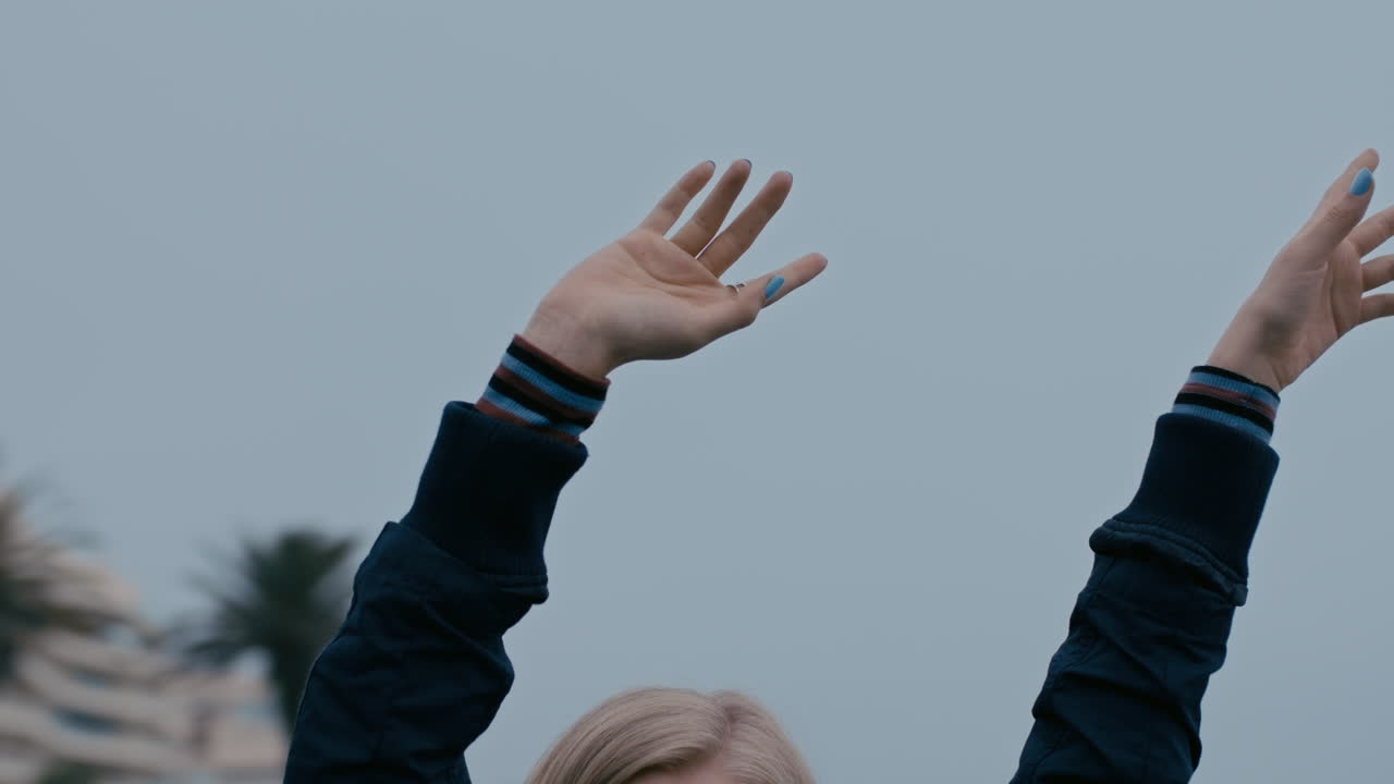 mujer joven con los brazos levantados en el tiovivo disfrutando del carrusel giratorio en el parque infantil explorando el concepto de libertad