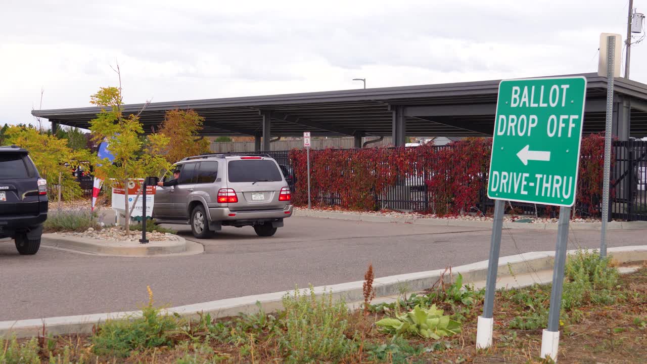 Men participate in democracy by submitting mail-in ballots directly from cars, underscoring safety, accessibility, inclusion, election integrity, civic engagement, and the convenience of modern voting