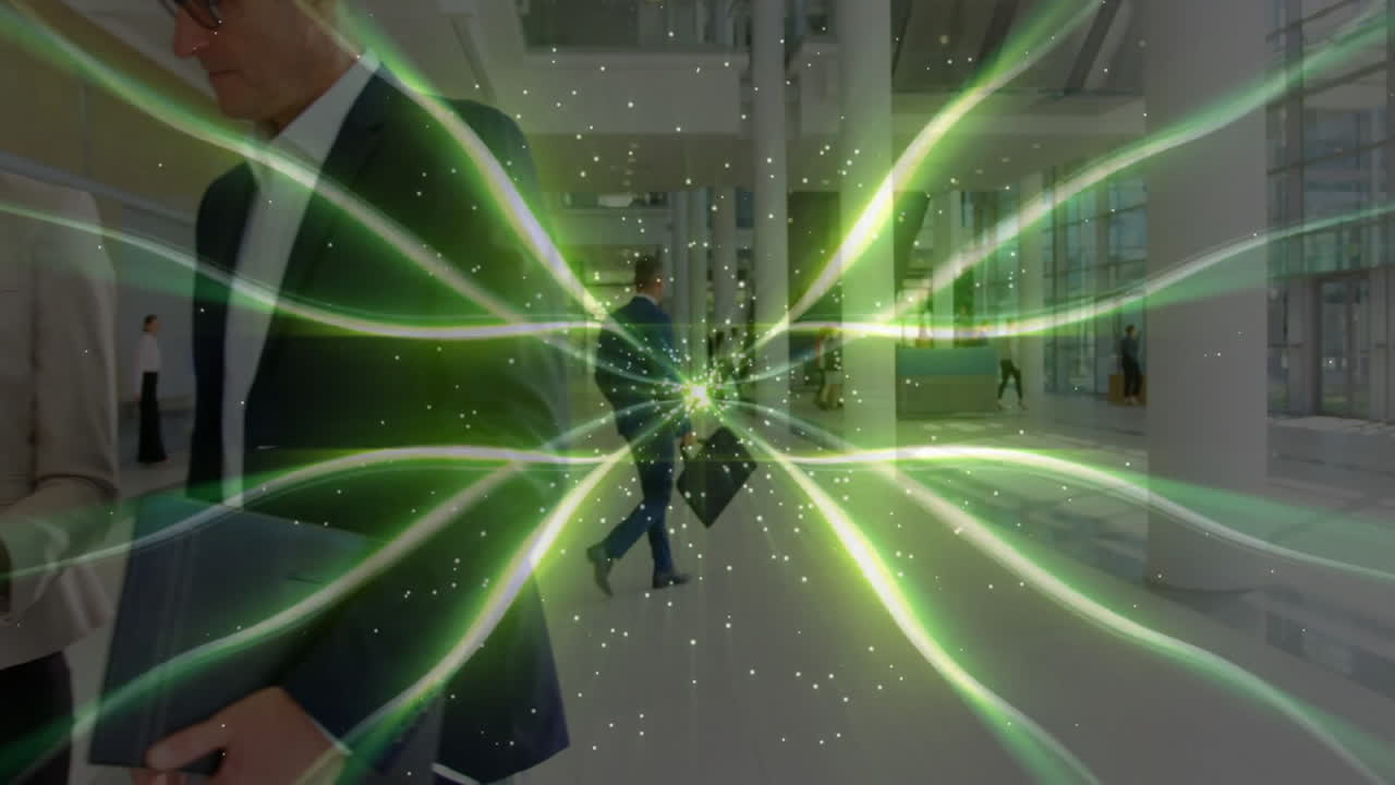 Two businessmen walking through corporate lobby, holding tablet, showing green glowing beams