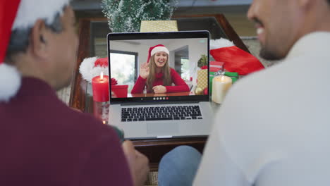 Padre-Birracial-Sonriente-Con-Hijo-Usando-Una-Computadora-Portátil-Para-Una-Videollamada-Navideña-Con-Una-Mujer-En-La-Pantalla