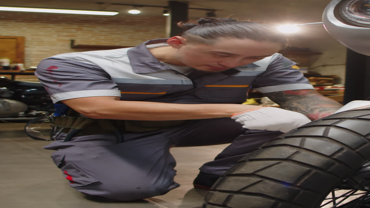 Multicultural Repairman Changing Tires of Motorcycle