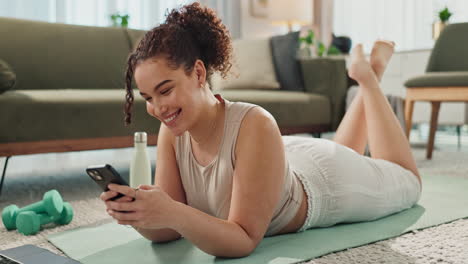 woman using phone while exercising at home