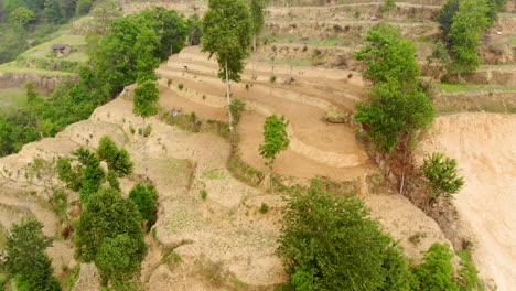 Aerial:-Man-working-in-a-field-in-the-mountains