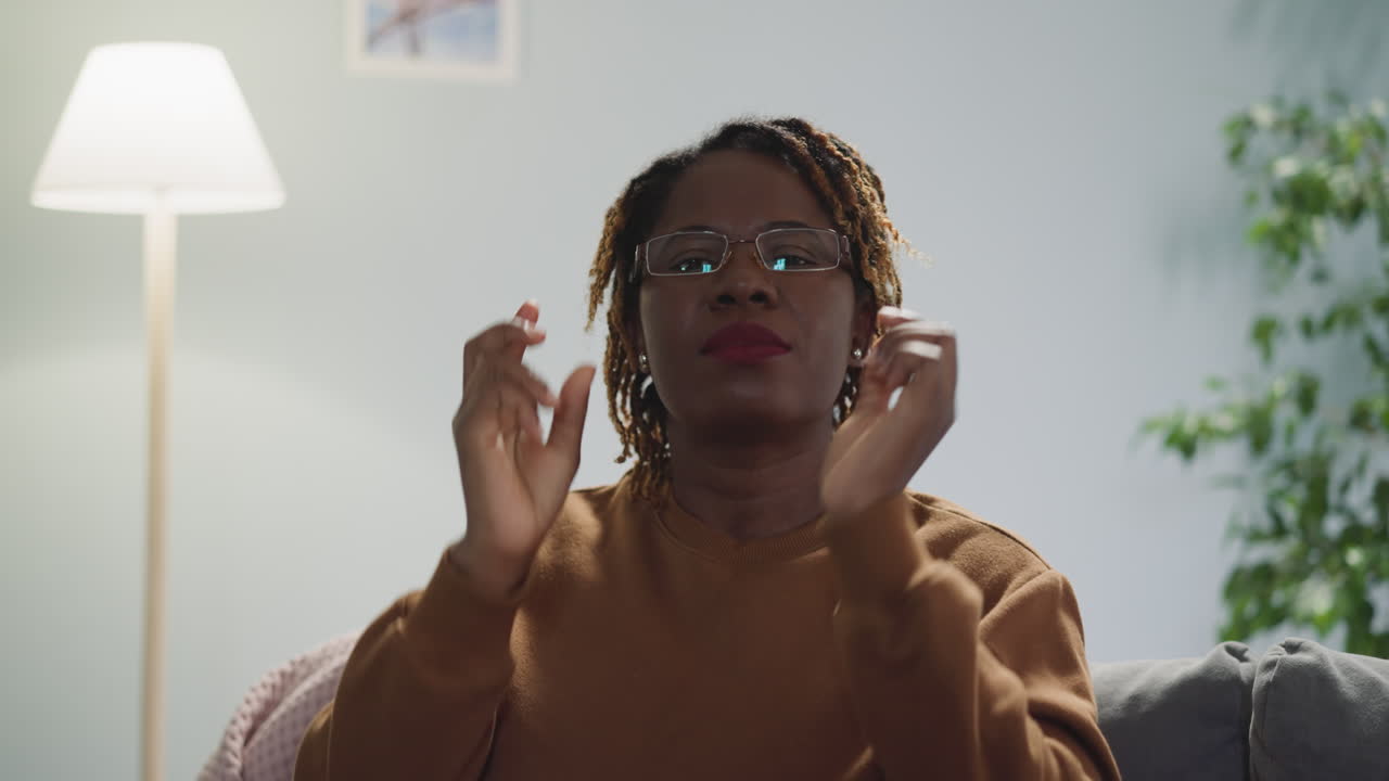 African American woman puts on glasses looking in camera