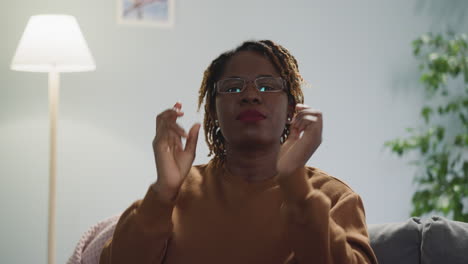 African-American-woman-puts-on-glasses-looking-in-camera