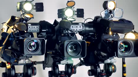 three working video cameras in a slow rotating shot.