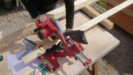 the craftsman saws the wood on the workbench