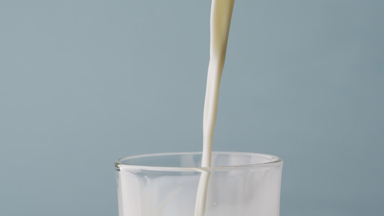 video de un vaso de leche con espacio de copia en un fondo azul